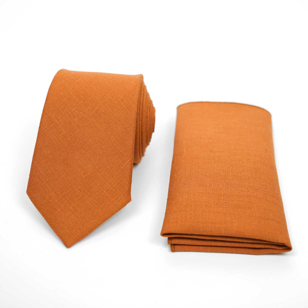Classic orange linen necktie and matching pocket square set, vibrant wedding accessories on a white background.