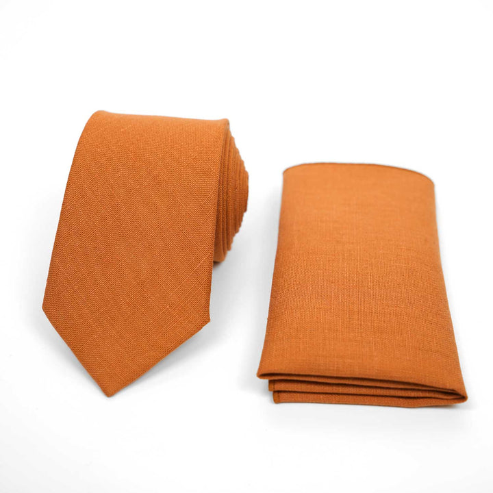 Classic orange linen necktie and matching pocket square set, vibrant wedding accessories on a white background.