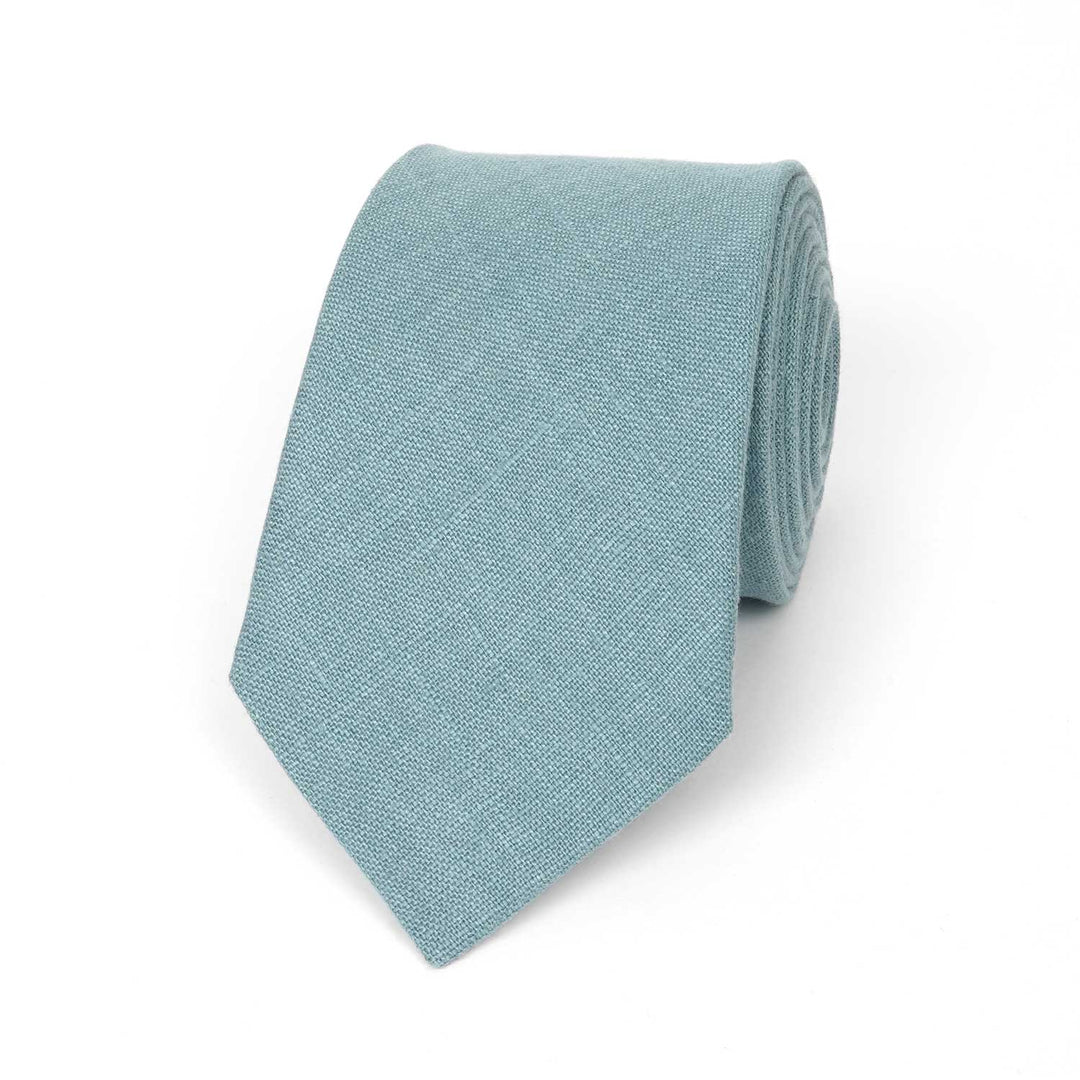 Handmade dusty blue linen necktie centered on a crisp white background.