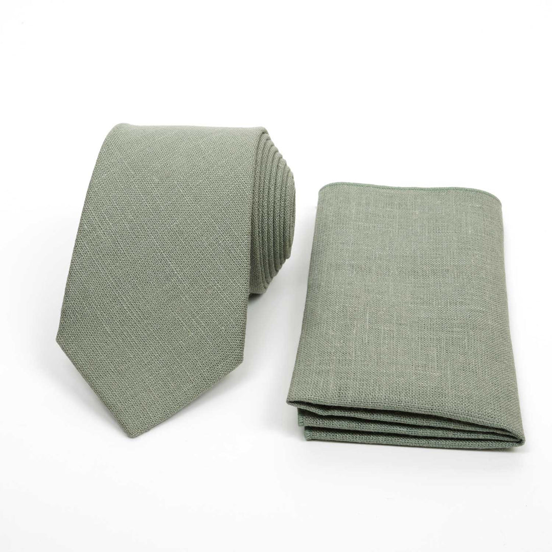 Eucalyptus green linen necktie and matching pocket square set, wedding accessories on a white background.