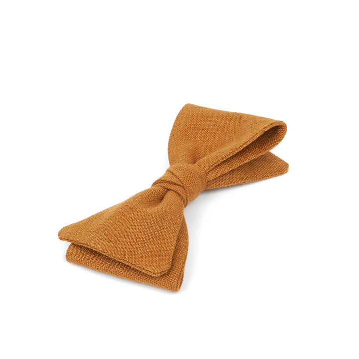 Close-up view of a Hemmitie cinnamon linen pre-tied bow tie showing the rich, warm fabric texture.