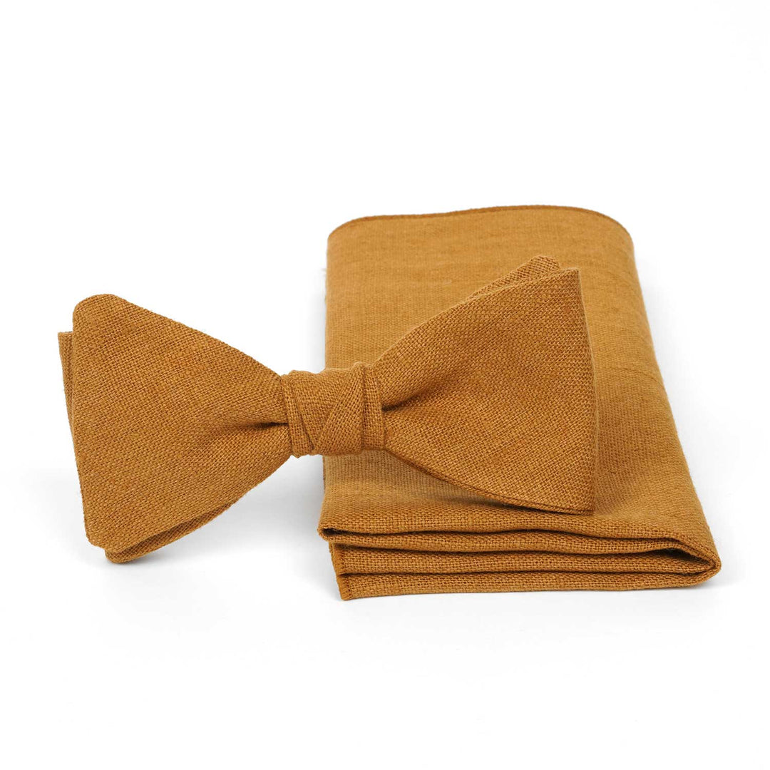 Cinnamon yellow linen pre-tied bow tie and matching pocket square set by Hemmitie on a white background.