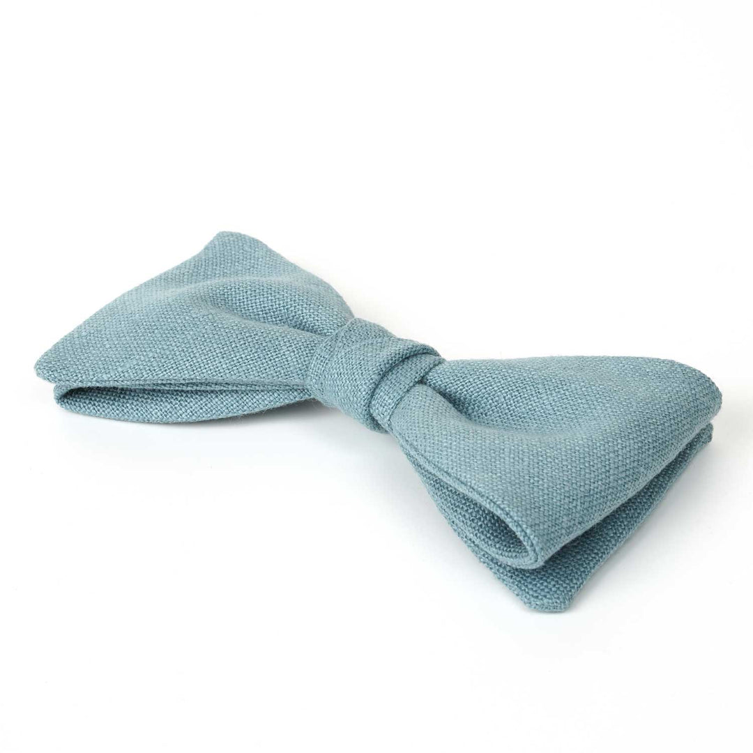Side view detail of a Hemmitie dusty blue linen pre-tied bow tie showing the high-quality fabric texture.