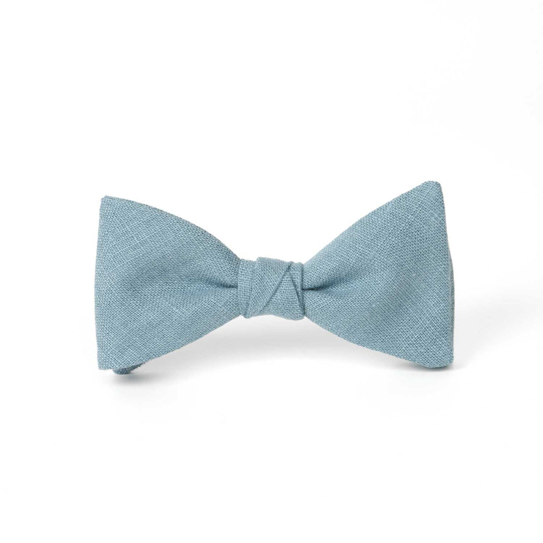Dusty blue linen pre-tied bow tie by Hemmitie, shown on a white background.
