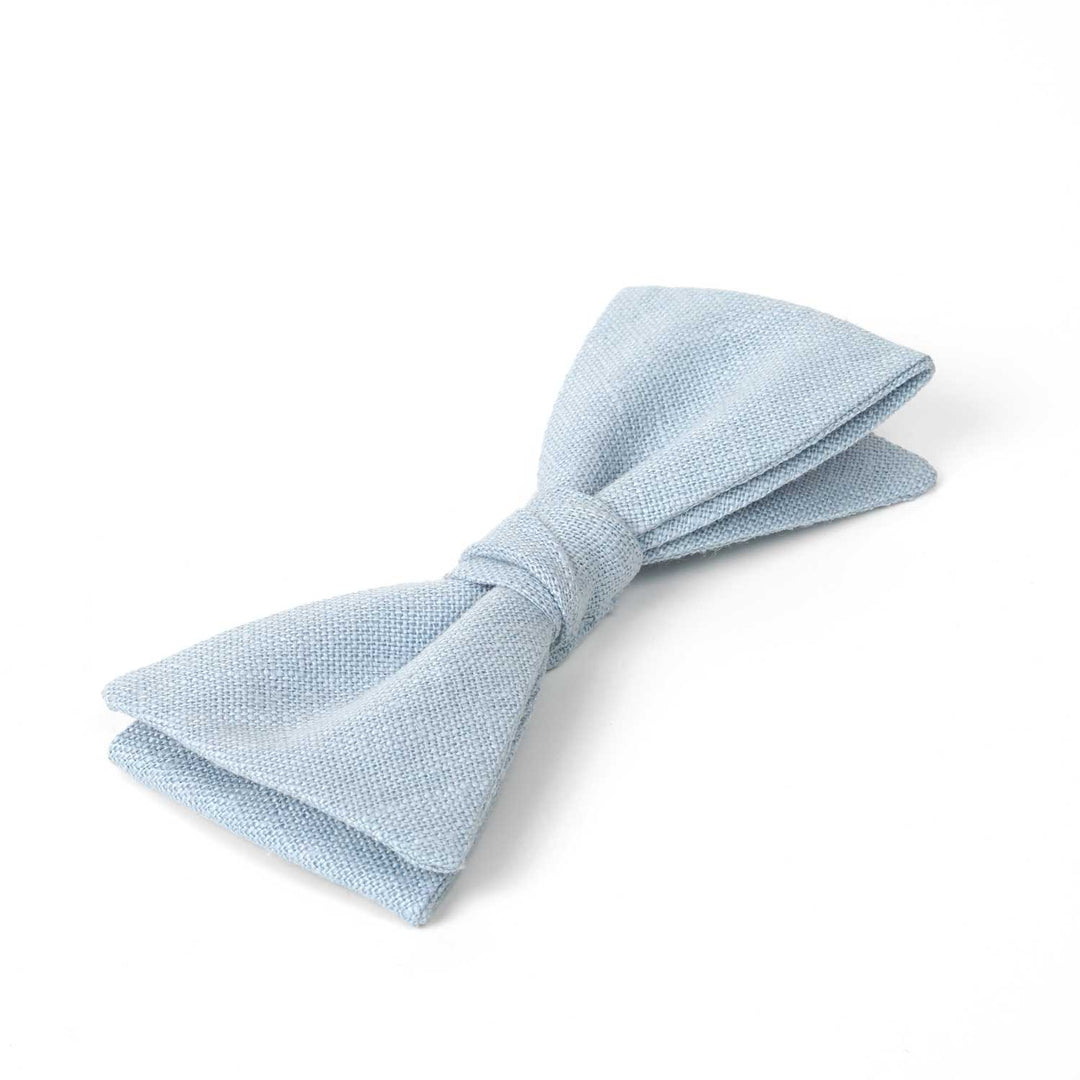 Side view close-up of a Hemmitie pale blue linen pre-tied bow tie highlighting the natural fabric weave and quality.