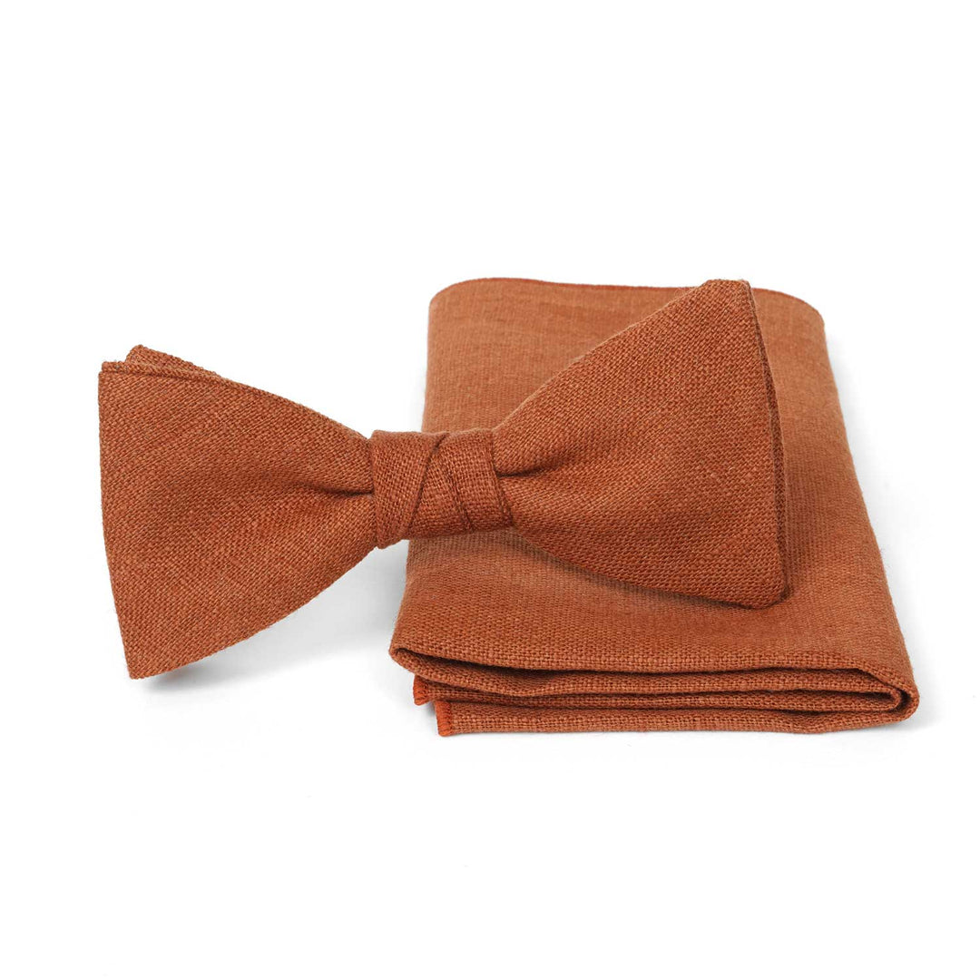 Terracotta linen pre-tied bow tie and matching pocket square set by Hemmitie on a white background.