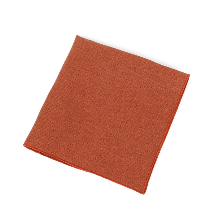 Terracotta linen pocket square by Hemmitie, showing the natural texture of the fabric.