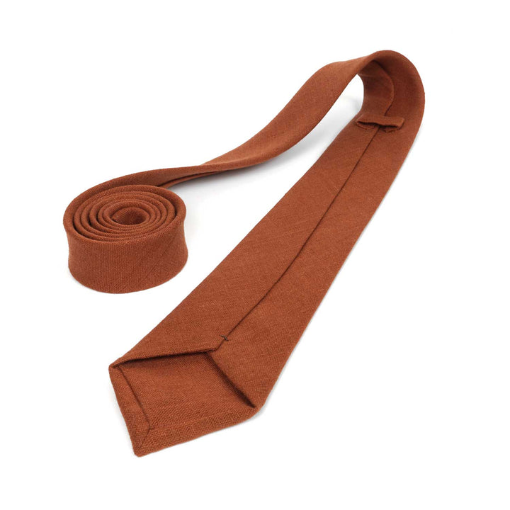 A close-up, zoomed-in view of the back of a Hemmitie terracotta linen necktie, showing the quality stitching and fabric texture.