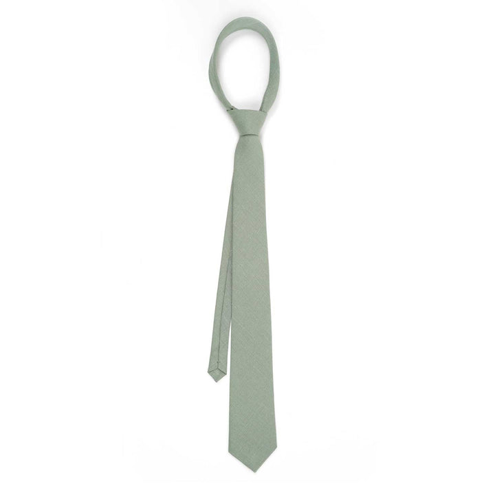 A light sage green necktie tied in a full knot, shown from the front on a crisp white background to highlight the fabric drape.