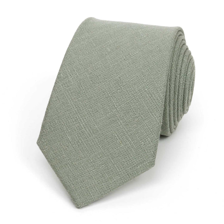 Modern sage green necktie made of textured linen fabric, isolated on a white background.