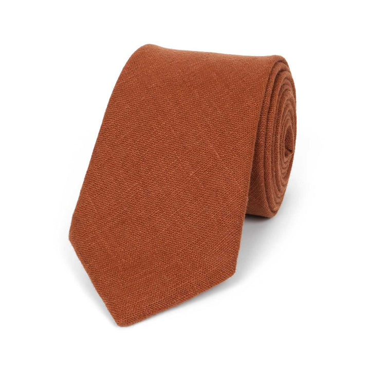 A terracotta orange skinny modern linen necktie by Hemmitie, displayed on a clean white background.