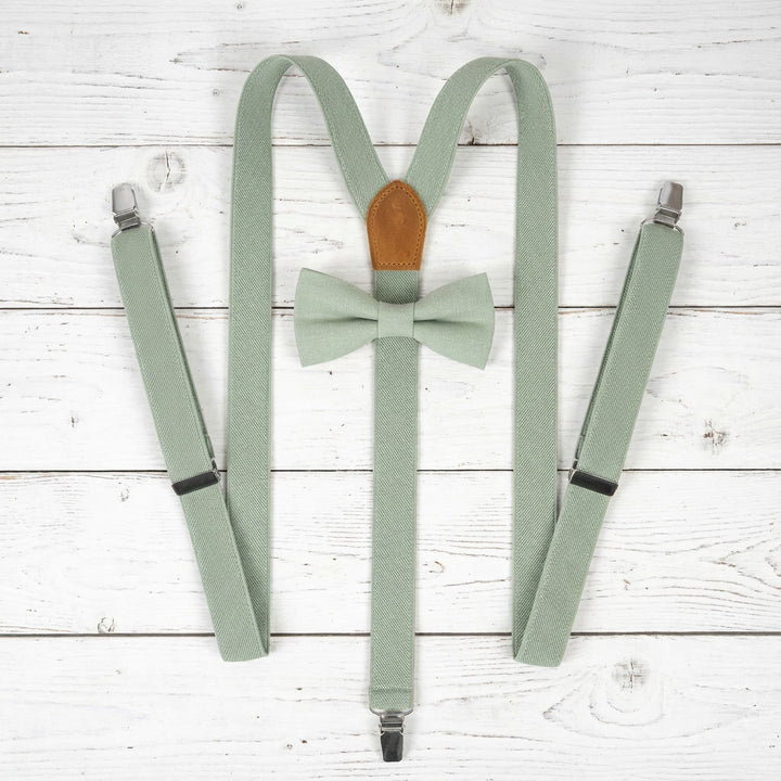 Full top view of Y-back elastic suspenders and linen bow tie set on wood background